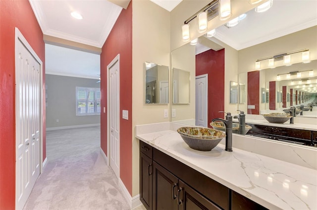 bathroom with baseboards, ornamental molding, a closet, and vanity