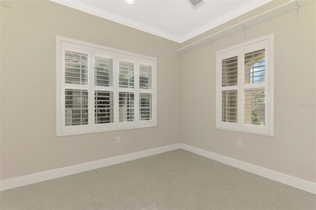 tiled spare room with ornamental molding and baseboards