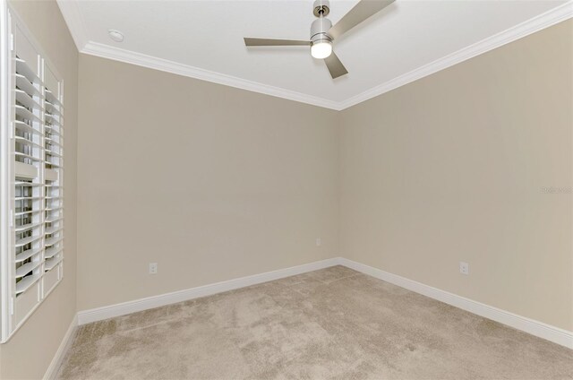 empty room with a ceiling fan, light carpet, crown molding, and baseboards