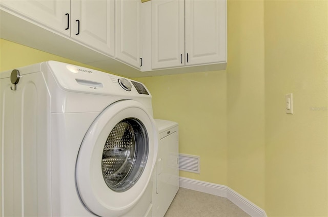 laundry room featuring visible vents, separate washer and dryer, cabinet space, and baseboards