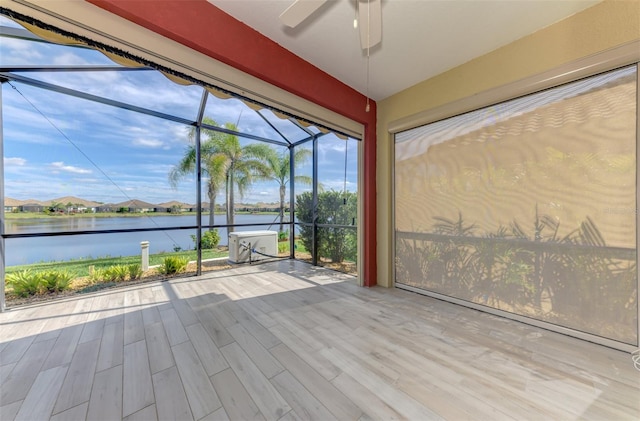 unfurnished sunroom with a water view and ceiling fan