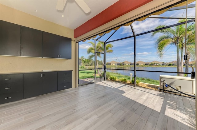 unfurnished sunroom featuring a water view and ceiling fan