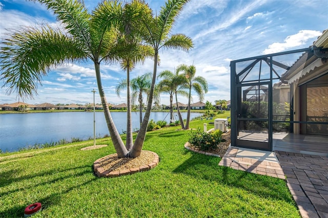 view of yard featuring glass enclosure and a water view