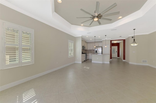 unfurnished living room with ornamental molding, a raised ceiling, visible vents, and baseboards