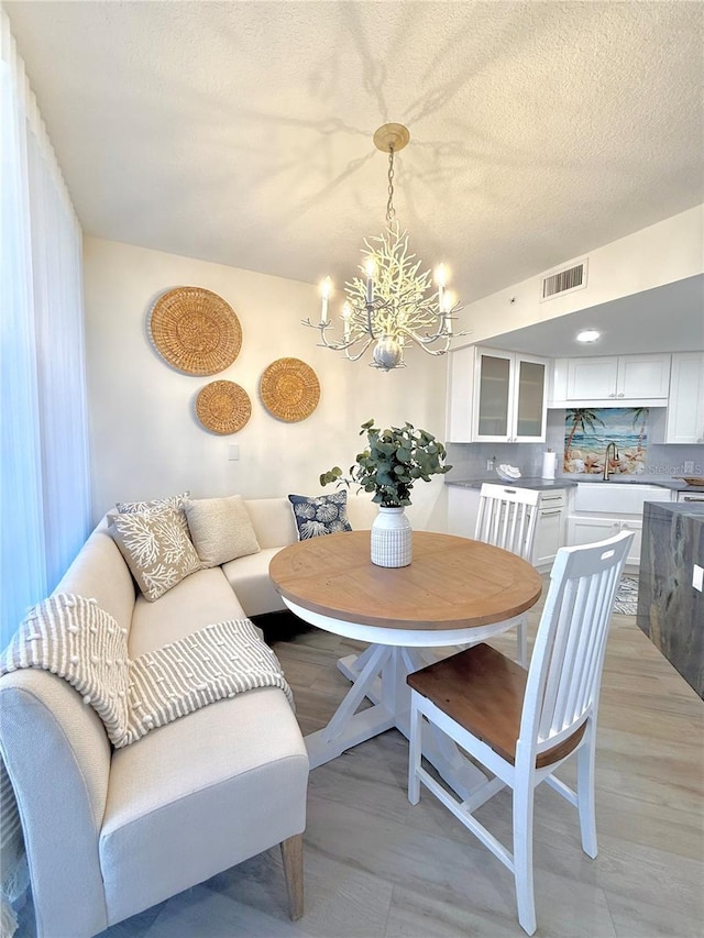 dining area with a textured ceiling and an inviting chandelier