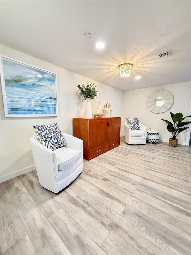 sitting room with a textured ceiling and hardwood / wood-style flooring