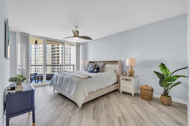 bedroom featuring access to exterior, a wall of windows, light hardwood / wood-style flooring, and ceiling fan