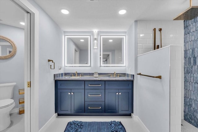 bathroom with a tile shower, vanity, and toilet