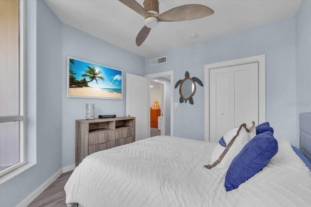 bedroom with hardwood / wood-style flooring, ceiling fan, and a closet