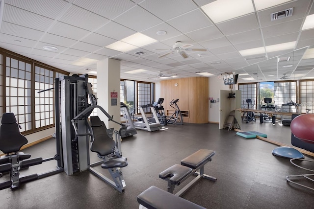 gym featuring a drop ceiling and ceiling fan