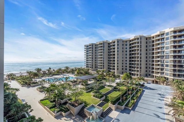 view of building exterior featuring a water view and a beach view