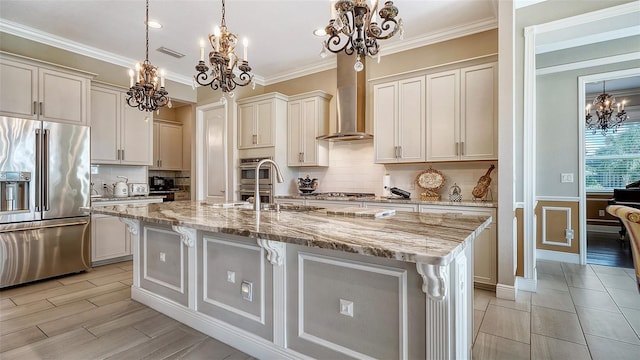 kitchen featuring a center island with sink, white cabinets, stainless steel appliances, and hanging light fixtures