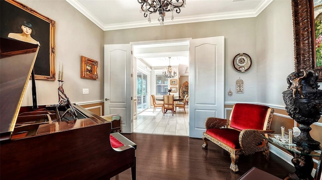 living area featuring hardwood / wood-style floors, ornamental molding, and a notable chandelier