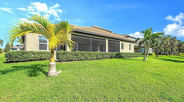 view of home's exterior featuring a sunroom and a yard