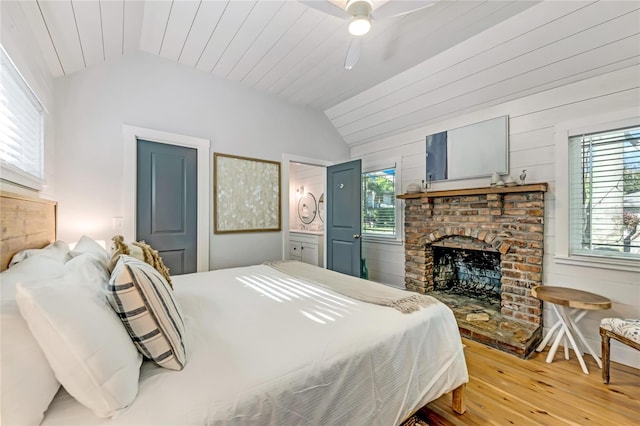 bedroom with vaulted ceiling, multiple windows, ceiling fan, and wood walls