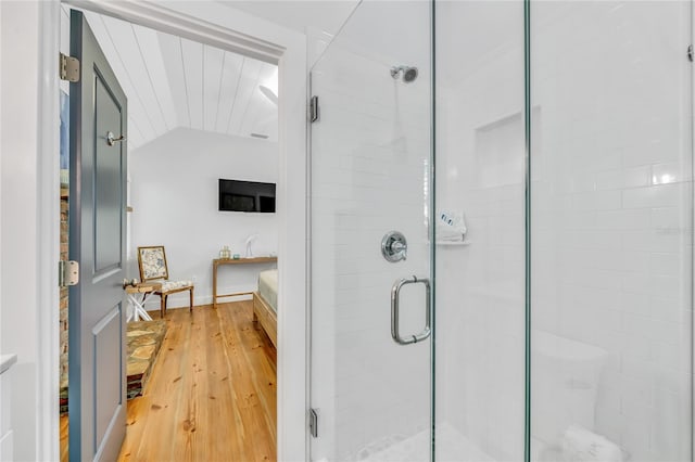 bathroom with vaulted ceiling, wood-type flooring, and an enclosed shower