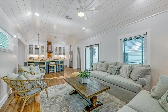 living room featuring a wealth of natural light, ceiling fan, wooden ceiling, and hardwood / wood-style flooring