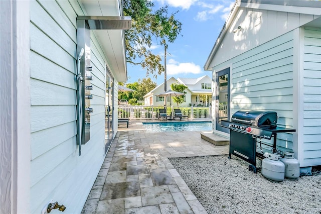 view of patio / terrace with a fenced in pool and a grill