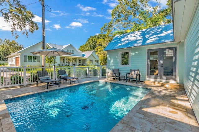 view of swimming pool featuring french doors and a patio