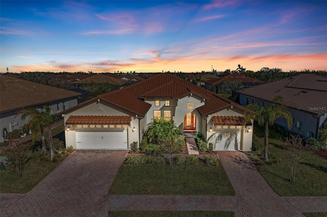 mediterranean / spanish house featuring a garage and a lawn