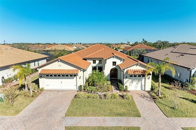 mediterranean / spanish home featuring a garage and a front lawn