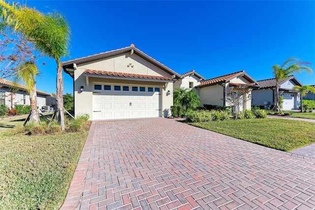 mediterranean / spanish-style house featuring a garage and a front yard