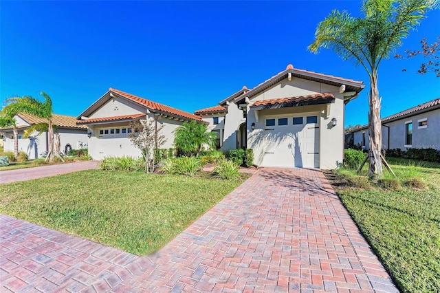 mediterranean / spanish-style home with a front yard and a garage