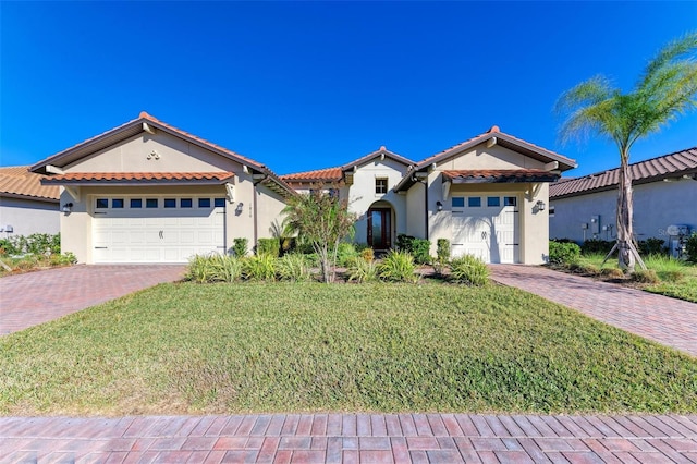 mediterranean / spanish-style house featuring a front lawn and a garage