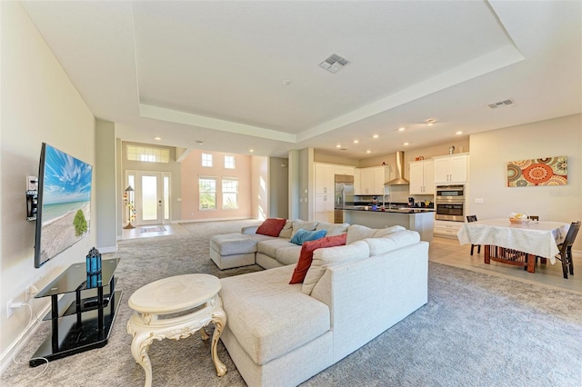 living room featuring french doors and a raised ceiling