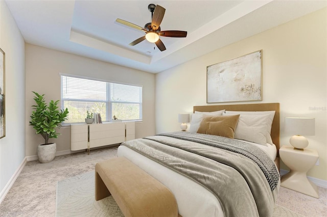 bedroom with ceiling fan, a raised ceiling, and light carpet