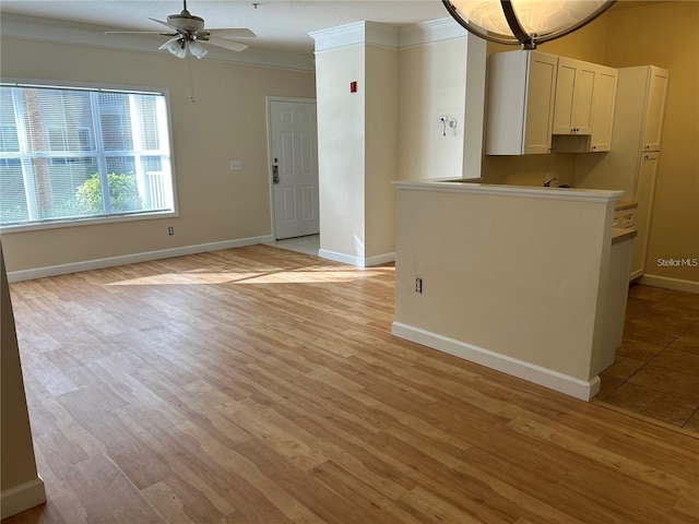 unfurnished living room featuring ceiling fan, light wood-type flooring, and crown molding