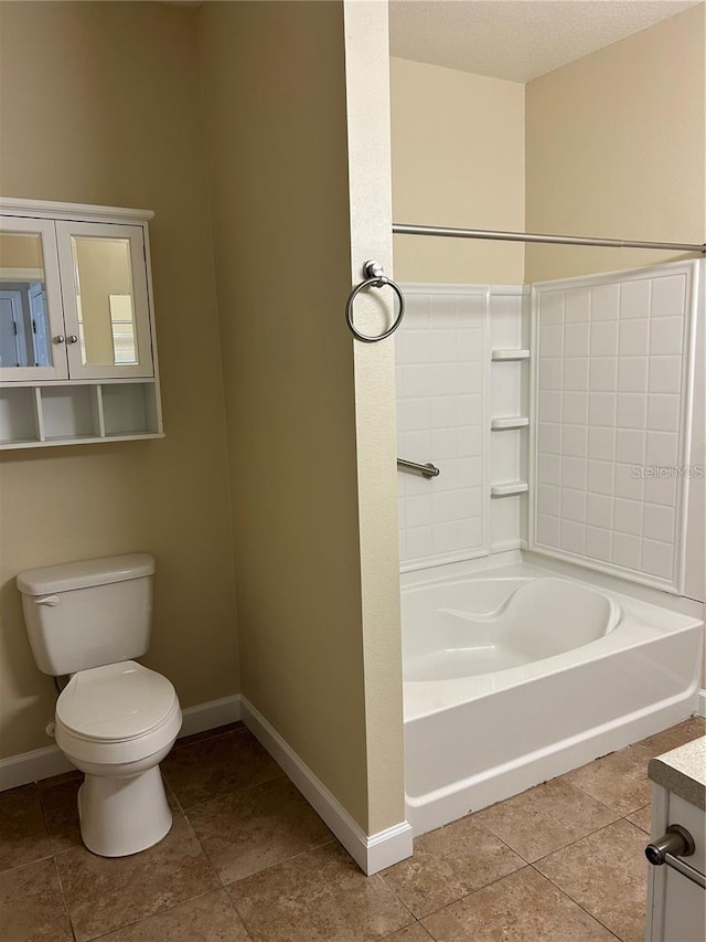 bathroom featuring vanity, a tub to relax in, and toilet