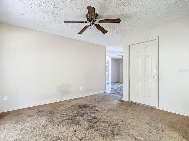 carpeted spare room with a textured ceiling and ceiling fan