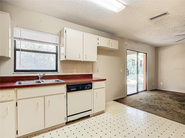 kitchen with dishwasher, sink, a textured ceiling, decorative backsplash, and white cabinets