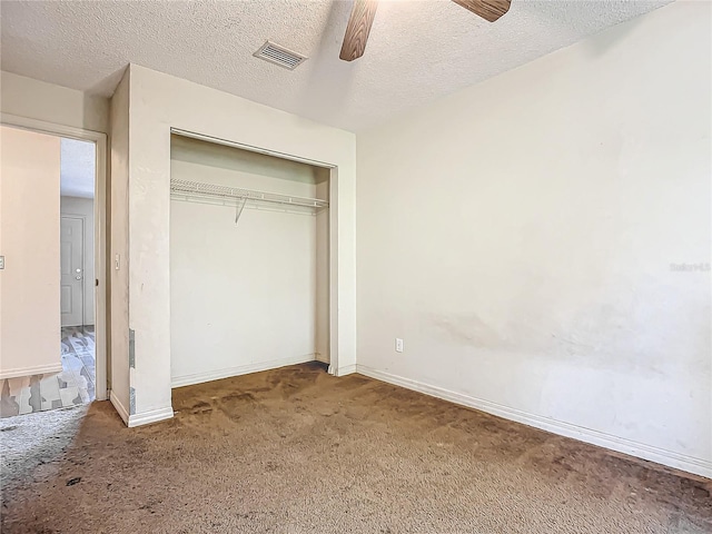 unfurnished bedroom featuring carpet flooring, ceiling fan, a textured ceiling, and a closet