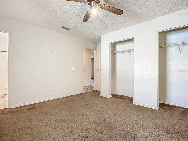 unfurnished bedroom with carpet, two closets, ceiling fan, and ensuite bathroom