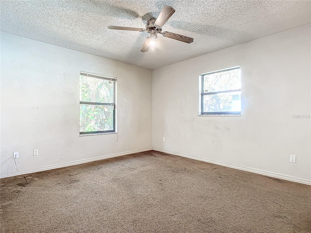 unfurnished room featuring carpet flooring, a textured ceiling, plenty of natural light, and ceiling fan