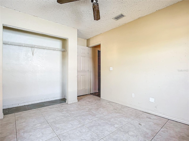 unfurnished bedroom featuring a textured ceiling, ceiling fan, and light tile patterned flooring