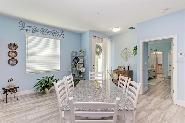 dining space with light hardwood / wood-style floors and a healthy amount of sunlight