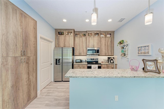 kitchen featuring decorative light fixtures, light stone counters, kitchen peninsula, and appliances with stainless steel finishes