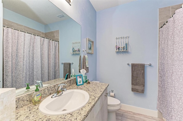 bathroom featuring hardwood / wood-style floors, vanity, and toilet