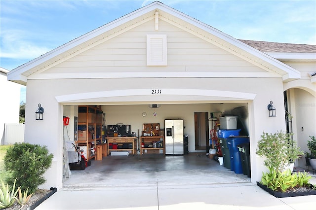 garage with stainless steel refrigerator with ice dispenser