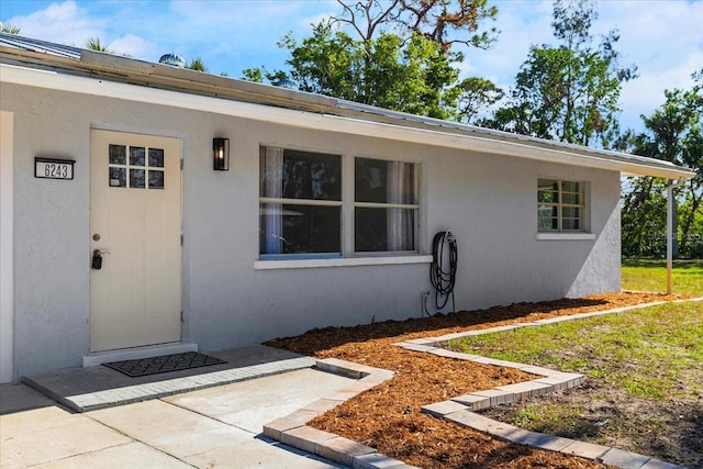 view of exterior entry featuring a yard