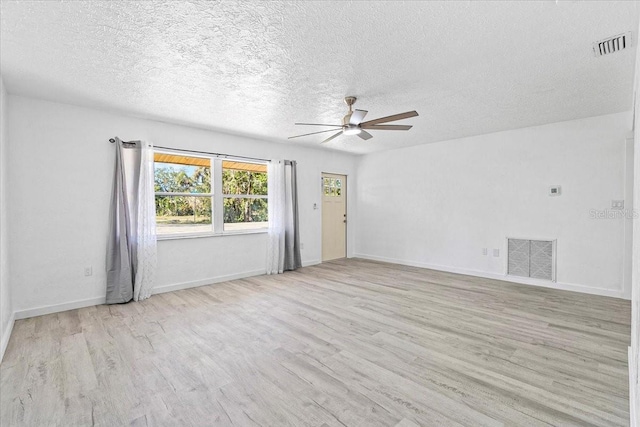 empty room with a textured ceiling, light hardwood / wood-style floors, and ceiling fan