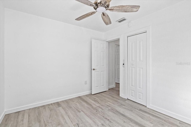 unfurnished bedroom featuring ceiling fan, light wood-type flooring, and a closet