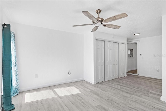 unfurnished bedroom featuring a textured ceiling, a closet, ceiling fan, and light hardwood / wood-style floors