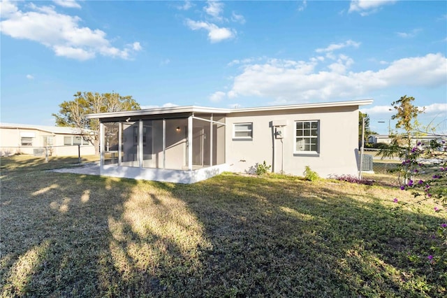 rear view of property featuring a lawn and a sunroom