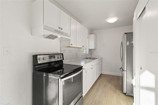 kitchen featuring light wood-type flooring, appliances with stainless steel finishes, sink, and white cabinets