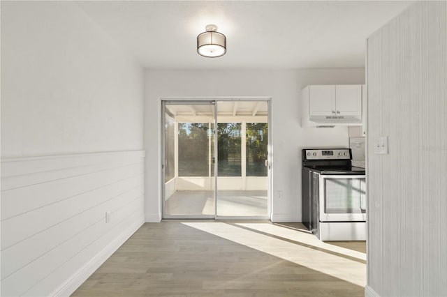 kitchen with light hardwood / wood-style flooring, stainless steel electric range, and white cabinets