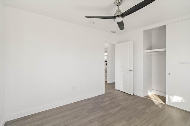 unfurnished bedroom featuring wood-type flooring, ceiling fan, and a closet